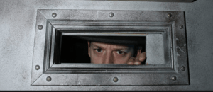 A guy looking through a steel window